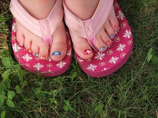 Painted toe nails on pink shoes on green grass