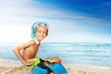 Wall Mural - Happy little diver sitting on the sandy beach