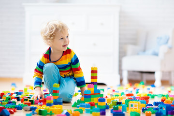 Child playing with toy blocks. Toys for kids.