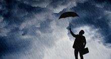 Businessman With Umbrella In The Rainstorm