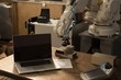 © Wavebreak Media - Laptop, robotic machine and remote control on table