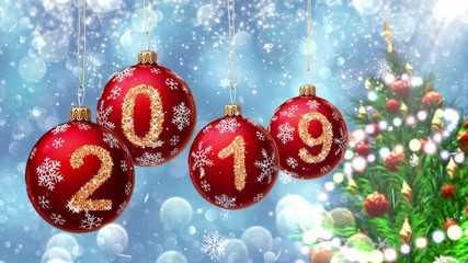 Wall Mural - red balls with numbers 2019 hanging on the background of a blue bokeh and a rotating christmas tree 