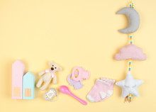 Baby Girl Accessories And Toys On Yellow Background With Copy Space