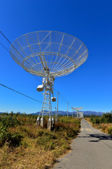 Array of satellite dishes or radio antennas against sky. Space o