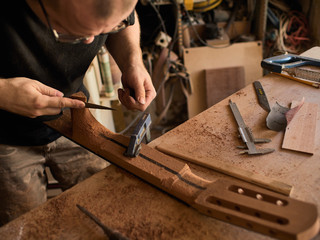 The guitar master makes a guitar neck.