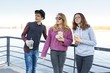 © Valerii Honcharuk - Lifestyle of adolescents, boy and two teen girls are walking in the city. Laughing, talking children eating street food, having fun. Background of the river embankment.