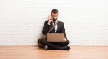 Businessman With His Laptop Sitting On The Floor Showing A Sign Of Closing Mouth And Silence Gesture