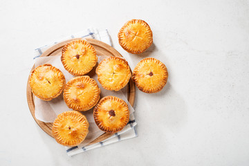 Wall Mural - Traditional Australian Mini meat pies from shortbread dough on a light gray background.