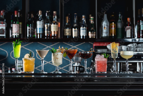 Fotografía row of various colourfull alcoholic cocktails on a bar desk