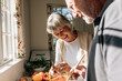 © Jacob Lund - Happy senior couple making food standing in kitchen
