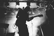 © kondrukhov - Guitarist silhouette on a stage in a bright stage lights. Black and white