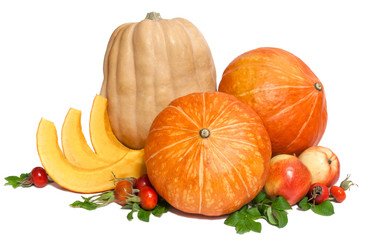 Wall Mural - Two orange and one yellow pumpkins with three slices , two apples and rosehips with leaves isolated on white