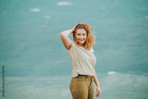 Fotografia Outdoor portrait of young woman next to storm lake on a windy day