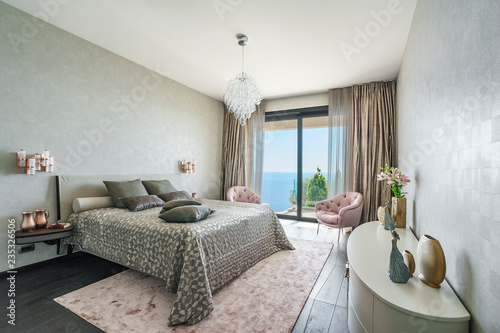 Interior Of A Spacious Light Bedroom With Windows In A