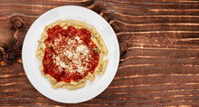 Penne Meal With Red Sauce And Grated Cheese, Wooden Background, Top View