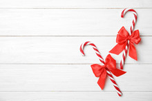 Flat Lay Composition With Tasty Candy Canes And Space For Text On Wooden Background