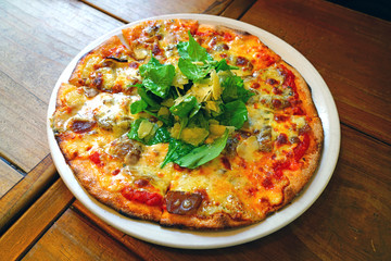 Wall Mural - A pizza with tomato sauce, cheese and arugula salad on top