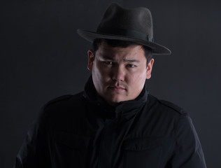 classic portrait of asian man in hat on black studio background