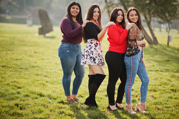 Wall Mural - Group of four happy and pretty latino girls from Ecuador posed at street.