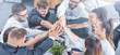 © REDPIXEL - Happy business people team giving high five in office.