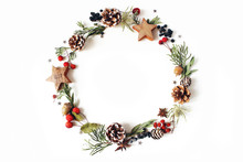 Christmas Circle Floral Composition. Wreath Of Cypress, Eucalyptus Branches, Pine Cones, Rowan Berries, Anise, Confetti Stars And Sea Holly Flowers On White Background. Winter Wedding Design. Flat Lay