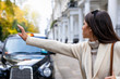 Attraktive Geschäftsfrau in London winkt ein schwarzes Taxi auf der Straße heran