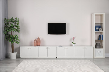 Modern TV set mounted on wall in living room