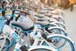 © tatomm - Bicycle rental service on city road parking with sunlight, public transportation concept.