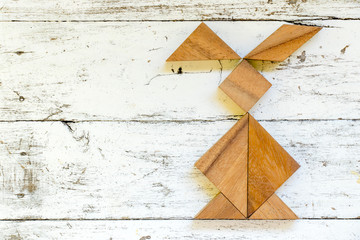 Wall Mural - Tangram puzzle in rabbit shape on old white wood background