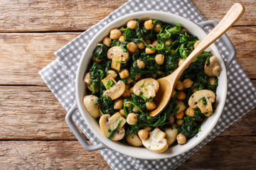 Wall Mural - Stew of chickpeas with spinach and mushrooms close-up in a bowl. horizontal top view