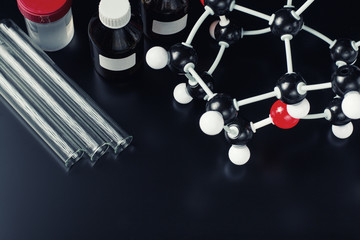 molecular formula and laboratory equipment on a dark background. Science organic chemistry concept