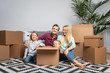 © snedorez - Picture of happy parents and children among cardboard boxes in new apartment