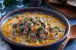 Chicken hearts stewed in sour cream in a clay bowl on a wooden stand, horizontal
