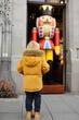 Little boy is looking big wooden Nutcracker toy at the traditional Christmas market of the Old city of Germany.