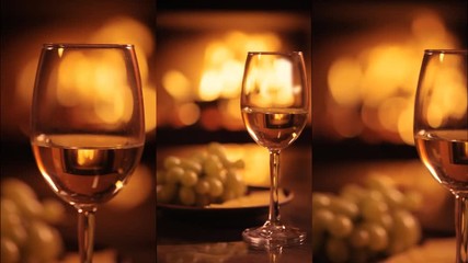 Wall Mural - Vertical videos of one white wine wineglasses over fireplace background. Slow motion.