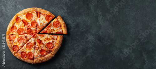 Fotomural Tasty pepperoni pizza and cooking ingredients tomatoes basil on black concrete background
