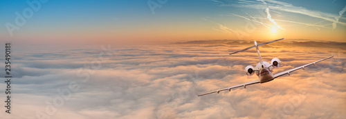Fotografía Private jet plane flying above dramatic clouds.