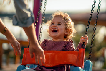 adorable little girl having fun on a swing