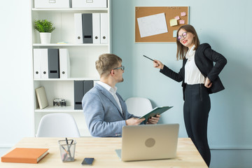 Business, teamwork and people concept - Portrait of serious man and attractive woman working at project in office.