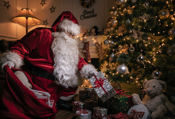 Santa Claus putting gifts under the christmas tree