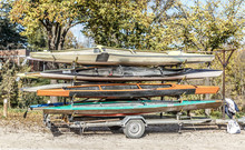 Four Canoes Of Different Colors Placed On A Trailer