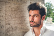 © angelocordeschi - Handsome young man portrait. Intense look and eye-catching beauty. Fashionable hair and beard. The young man is wearing a white shirt.