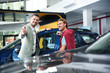 Salesman with customer in modern car dealership