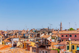 Fototapeta Miasto - Terracotta rooftops of venetian houses under blue sky in Venice, Italy