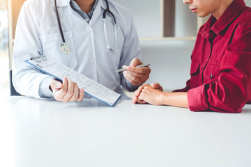 Wall Mural - Doctors and patients sit and talk. At the table near the window in the hospital.