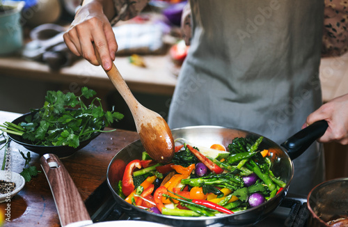 Cuadros en Lienzo Woman cooking stir fried vegetables