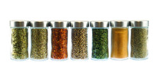 Collection Of Spice And Herbs Seasoning In Glasses Bottles Isolated On White Background