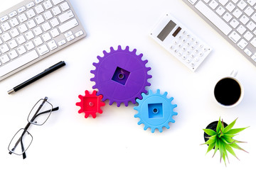 Poster - Teamwork in business concept. Toy gears on white office desk with computer keyboard top view copy space