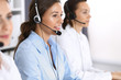 © rogerphoto - Call center. Group of operators at work. Focus at beautiful business woman in headset