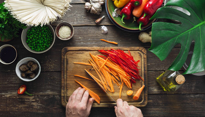 Wall Mural - Male hands prepare vegetarian thai noodles table home kitchen top view